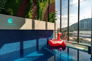 a swimming pool with a red swan in a building at D'Moon Escapes Ampang KL 4BR in Kampong Ulu Kelang