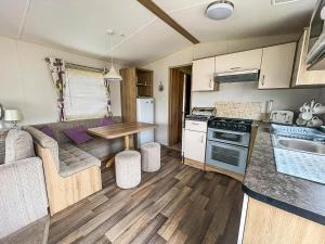 a kitchen and living room with a couch and a table at Lovely Caravan For Hire Nearby Scratby Beach In Norfolk Ref 50045L in Great Yarmouth