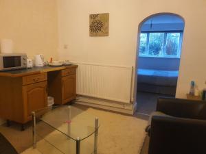 a living room with a glass table and a window at Burton Road Serviced Accommodation in Derby +3 photos