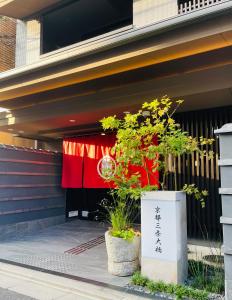 a building with a red curtain and some plants at Kyoto Sanjo Ohashi in Kyoto