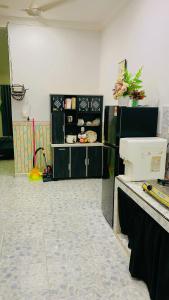 a room with a kitchen with a table and a counter at Aizat Homestay Tembila Besut Murah in Jertih +6 photos