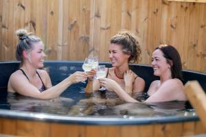 three women drinking champagne in a hot tub at Lønstrup Strandhotel in Lønstrup