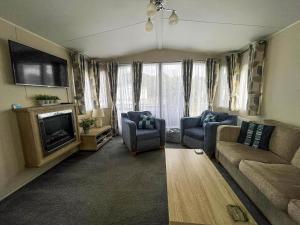 a living room with a couch and a tv at 6 Berth Caravan With Wifi At Wells-Next-The-Sea In Norfolk Ref 72032T in Wells next the Sea