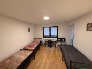 a room with two beds and a desk in it at Big, cosy and central apartment in Karlsruhe