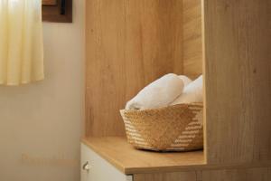 a basket of towels sitting on a shelf in a bathroom at Porto Athos apartments 1345 in Nea Roda +32 photos
