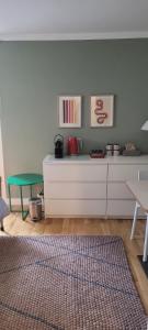 a living room with a white cabinet and a green table at Ruffinis Souterrain in Gräfelfing
