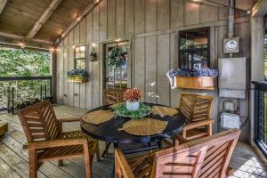 a patio with a table and chairs and a refrigerator at Firefly Lookout in Townsend