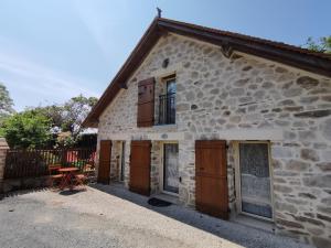 a stone house with wooden doors and a window at La petite porcherie in Ladignac-le-Long +34 photos