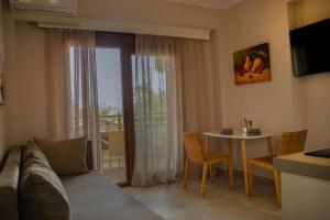 a living room with a couch and a table with chairs at Porto Athos apartments 1345 in Nea Roda