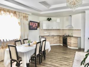 a kitchen and dining room with a table and chairs at Дом в Боровом in Borovoye