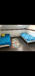 two twin beds in a room with a rug at Maison calme avec piscine privée in Argenteuil