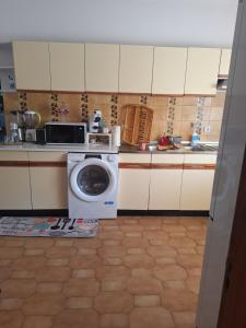 a kitchen with a washing machine in a kitchen at Romao in Monsoa