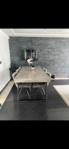 a table in a room with a brick wall at Maison calme avec piscine privée in Argenteuil