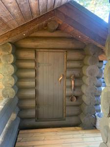a front door of a log cabin with a roof at Russet & Rowanberry - Russet House in Paide