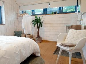 a bedroom with a bed and a chair and a plant at Nature Circuit Francorchamps in Stavelot