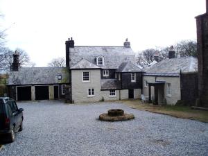 Una casa grande con una entrada para autos en frente de ella en Tor Royal Farm House, en Princetown