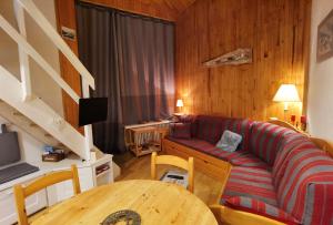 a living room with a couch and a table at MyHome - Génépis 29 - 4pax skis aux pieds Val Claret in Tignes