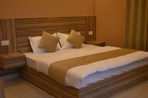 a bedroom with a large bed with white sheets and pillows at Zankhrpas A Himalayan Home - Manali in Manāli