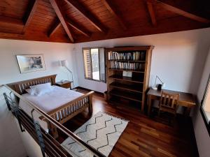 a bedroom with a bed and a desk and a book shelf at Casa Tagoro, facing the Ocean in Tacoronte