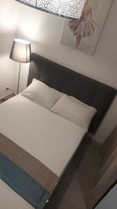 a bed with a black headboard and white pillows at Villa Alex 2 in Toulouse