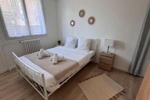 ein Schlafzimmer mit einem Bett mit zwei Handtüchern darauf in der Unterkunft Appart cozy dans le centre-ville, 6 pers in Neuilly-Plaisance