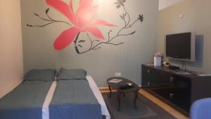 a bedroom with a bed with a flower on the wall at Konak Apartment in Sarajevo