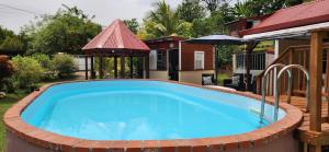 a large swimming pool in a yard with a house at Vacances Antilles in La Trinité