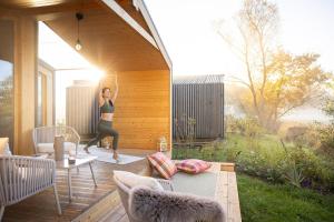 Eine Frau macht eine Yoga-Pose auf einem Deck. in der Unterkunft ElboTinyhouse in Bleckede
