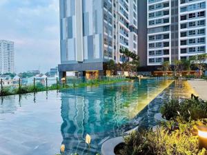 a swimming pool in front of a tall building at Happy One Central - Thủ Dầu Một Binh Duong in Ấp Phú Thọ