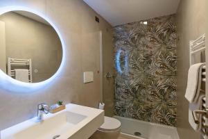 um banheiro com pia e chuveiro com espelho em Hotel Paba em Roma