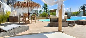 a patio with chairs and umbrellas next to a pool at Kopań Kabana in Darłowo