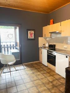 a kitchen with a table and a chair in it at Urlaub in der Eifel direkt am Rursee - Seewinkel in Simmerath