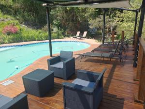 a swimming pool with chairs and an umbrella at Sabie Star in Sabie