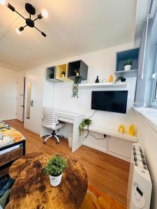 una sala de estar con un escritorio y una mesa en A - Newley Renovated Private Self-Contained Room in a Shared Apartment in Birmingham City Centre, en Birmingham