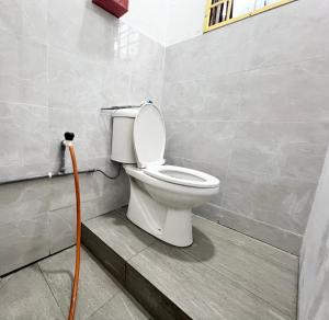 a bathroom with a toilet with a hose at CikSiti homestay02 in Kajang +9 photos