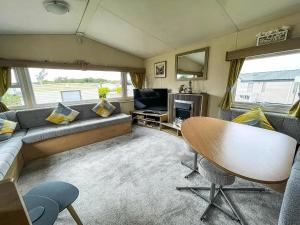a living room with a couch and a television at Brilliant 6 Berth Caravan With Decking At Heacham Beach Park Ref 21031A in Heacham