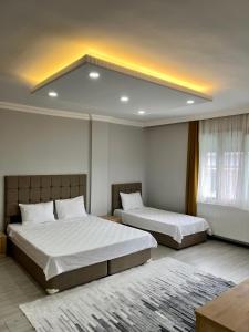 a bedroom with two beds and a large window at Ozn Suit Airport Hotel in Arnavutköy
