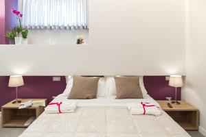 una camera da letto con un grande letto bianco con due tavoli di l'angolo di Frima a Matera