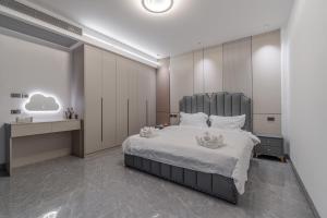ein Schlafzimmer mit einem großen Bett mit weißen Laken und Kissen in der Unterkunft T M L-Manor House 6 bedroom-independent swimming pool and powerful KTV in Ban Huai Yai + 31 Fotos