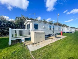 a mobile home in a yard with a fence at Lovely Dog Friendly Caravan For Hire At California Cliffs, Norfolk Ref 50027K in Great Yarmouth