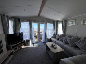 TV a/nebo společenská místnost v ubytování 6 Berth Caravan With Stunning Sea Views And Decking To Relax On, Ref 32048Az