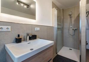 a bathroom with a white sink and a shower at Ferienwohnung Alpenzauber am Eberlhof in Schechen