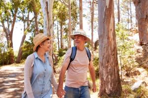 an older man and woman walking in the woods at Pet Friendly, Luxury Lodge With Decking In Suffolk Near The Beach Ref 32108A in Lowestoft