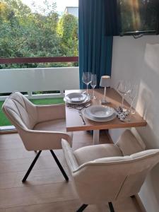 a dining room table with two chairs and wine glasses at Appartement AquaQuelle in Bad Füssing