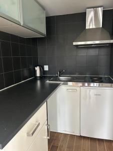 a kitchen with white cabinets and a black counter top at Privat och lyxig in Landvetter