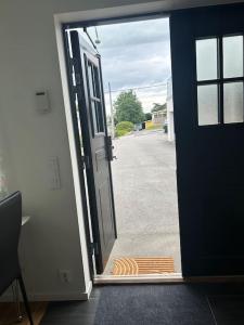 an open door to a driveway with a mat outside at Privat och lyxig in Landvetter