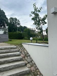 a set of stairs next to a building with a tree at Privat och lyxig in Landvetter