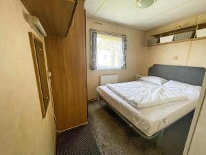 une petite chambre avec un lit et une fenêtre dans l'établissement Brilliant 8 Berth Caravan At Valley Farm Holiday Park, Essex Ref 46443V, à Great Clacton