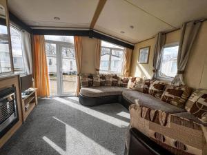 a living room with couches and a flat screen tv at Lovely 6 Berth Caravan With Free Wifi At Sand Le Mere, Yorkshire Ref 71011C in Tunstall