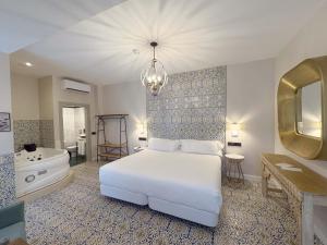 バダホスにあるAkla Hotel Badajozのベッドルーム(白いベッド1台、バスタブ、シンク付)